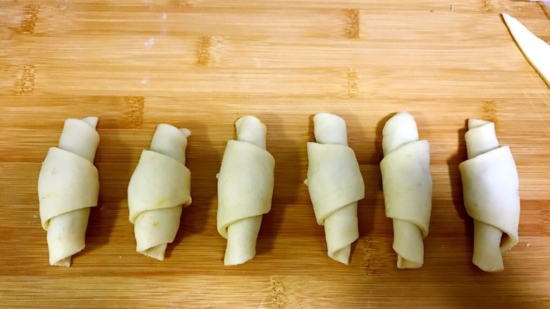 薯蓉&板栗蓉可颂小羊角面包,卷一排小羊角，放在烤盘上进行二次发酵，要发酵到2或2.5倍大。