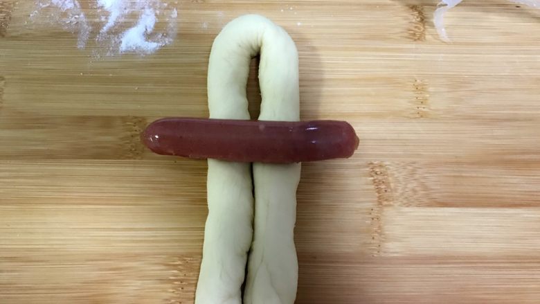 薯蓉&板栗蓉可颂小羊角面包,拿一根小香肠放在上面，把下面的向上折。