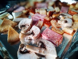 凯撒沙拉(家常版),把蘑菇培根放入烤盘 撒上少许盐 黑胡椒 放入烤箱200℃烤10分钟
