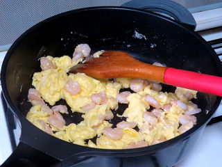 宴客快手菜【虾仁滑蛋】,油留锅中，用来炒蛋。锅烧热，大火，倒入蛋液和虾仁快速炒几下