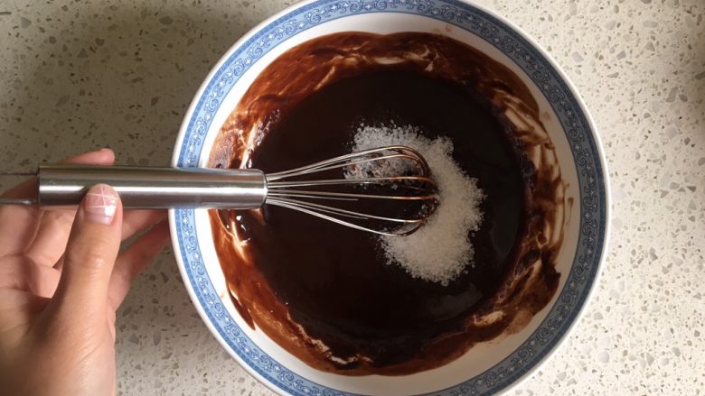 浓情布朗尼芝士蛋糕,完全融化搅拌均匀的黑巧黄油取出，加入细砂糖，继续搅拌至糖融化