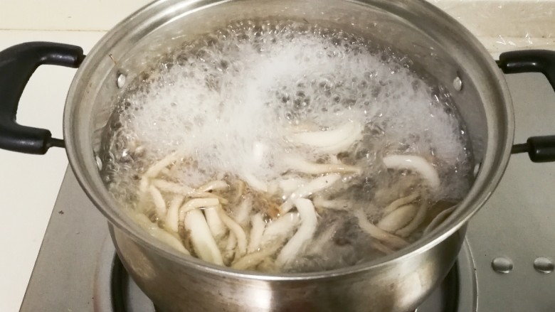 鲜美嫩滑蟹味菇烧嫩豆腐汤,锅中水开放入蟹味菇烧开捞出来
