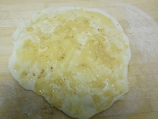 油酥饼,用擀面杖把醒好的面团擀薄，均匀涂上油酥、十三香和盐。