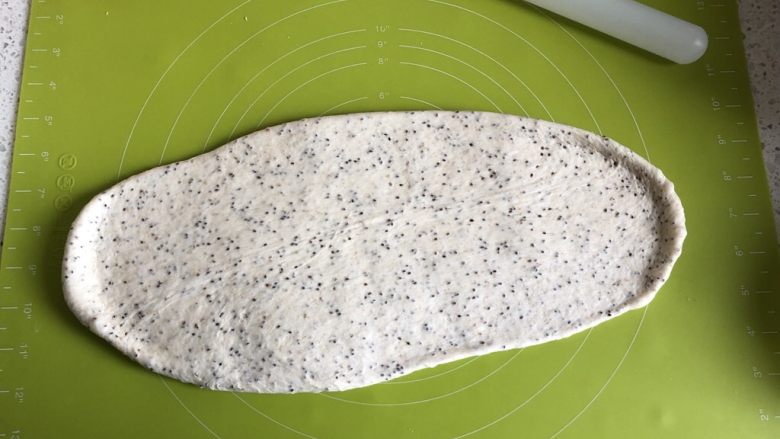 奇亚籽蜜豆燕麦欧包,发酵好的面团放在揉面垫子上，擀压排气