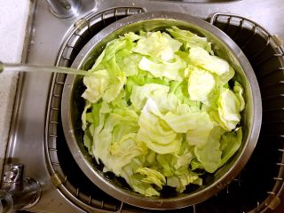 手撕包菜,把撕好的叶片浸入加盐的水中，泡半小时后，捞出洗净，沥干水分。