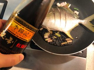 红烧金鲳鱼,加入葱白，料酒、生抽、红烧汁和适量水。