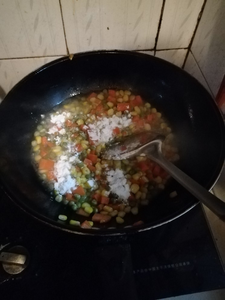 松仁玉米,再在锅里撒上干淀粉，翻炒均匀。注意:一定要多多翻炒不然容易糊锅。