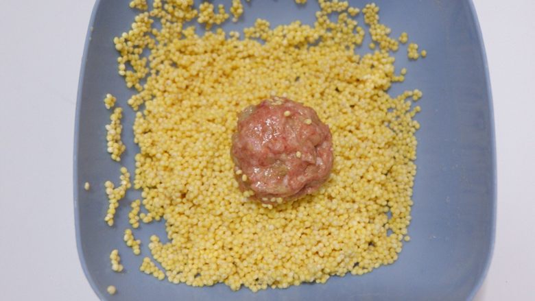 宝宝辅食—大黄米猪肉丸,放入大黄米中均匀的滚沾一圈。