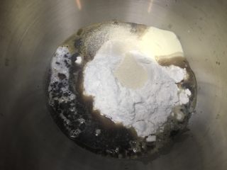 软绵绵黑糖吐司,面盆里加入面粉，奶粉，盐，顶部挖坑埋入酵母。然后加入放温的黑糖糖水和水A。