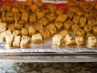 豆腐素食炒饭,、烤箱预热到400度，将沥干的豆腐放进烤箱，烤25分钟，这时豆腐表皮会变成漂亮的金黄色。