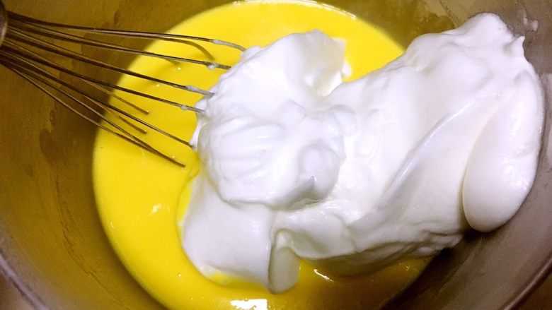 心心相印蛋糕,取三分之一打发好的蛋白，加入到蛋黄糊中，用蛋抽翻拌均匀