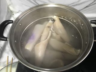 自制皮冻入口即化,2. 将洗干净的肉皮凉水下锅。开水煮沸猪皮煮卷，把沫撇一下，煮十分钟。