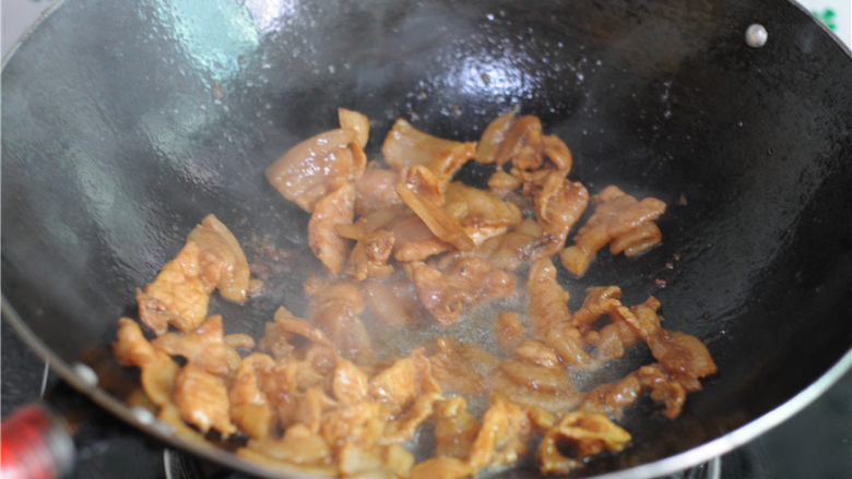 双椒花菇炒肉片,油锅烧热，将腌制好的肉片倒进去，煎炒至微微出油