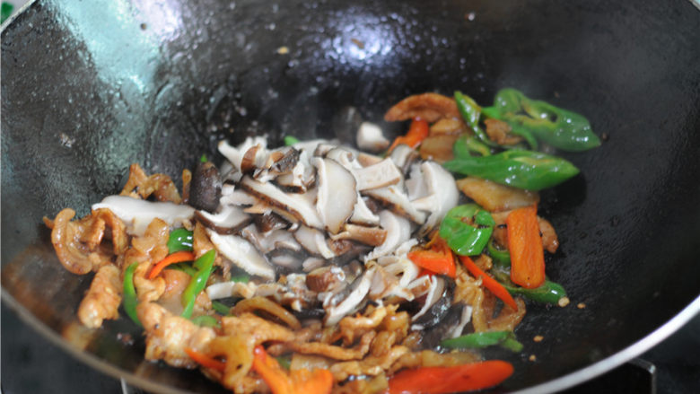 双椒花菇炒肉片,将汆烫好阿德花菇片倒进去一起翻炒至上色。