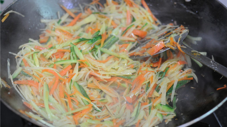 蒸饼卷菜,加入胡萝卜丝和黄瓜丝一起炒熟，加盐调味即可出锅备用