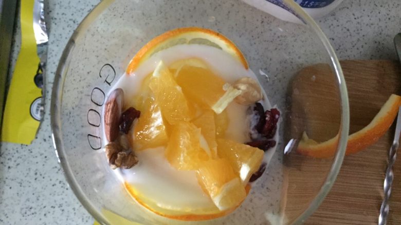 橙香酸奶杯,再倒2厘米酸奶，两边放坚果，中间放橙肉