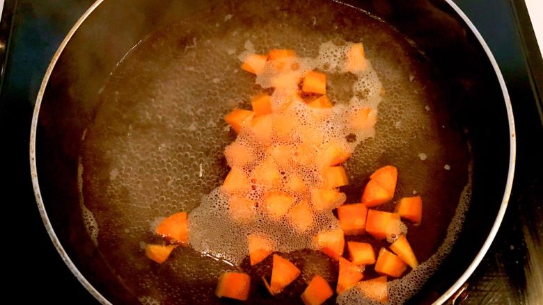牛油果焗虾仁,锅里加入冷水，烧开后放入胡萝卜丁焯水1分钟