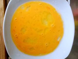酸黄瓜吐司卷,将鸡蛋打入盘中，迅速搅拌至均匀混合。