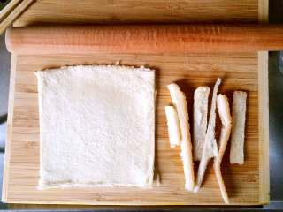 酸黄瓜吐司卷,取一片吐司面包，将四周用刀切掉，用擀面杖尽可能的将其擀薄，且紧实。