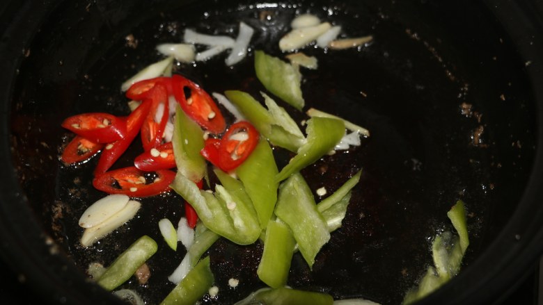 爆炒猪肝,锅底留底油，爆香葱姜蒜，放入红绿辣椒翻炒。