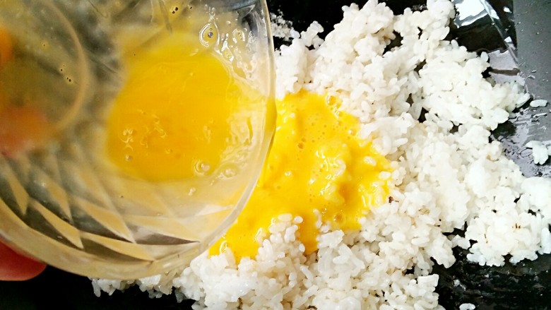 吉祥如意蛋炒米,然后在米饭上倒入打散的鸡蛋。