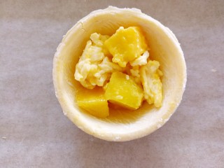 快手芒果酥～蛋挞皮版,挖一勺芒果和芝士碎的混合物放在蛋挞皮上
