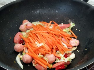 香辣小炒面（制作碱面过程）,放入胡萝卜丝煸炒几下。
