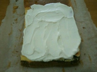 可可旋风卷,蛋糕分成两半，分别抹上奶油卷起来，用保鲜膜包好放冰箱冷藏定型。