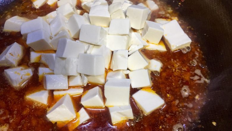#年味儿#红红火火麻婆豆腐,加入150ml清水，从盐水中滤起豆腐丁放入锅里
