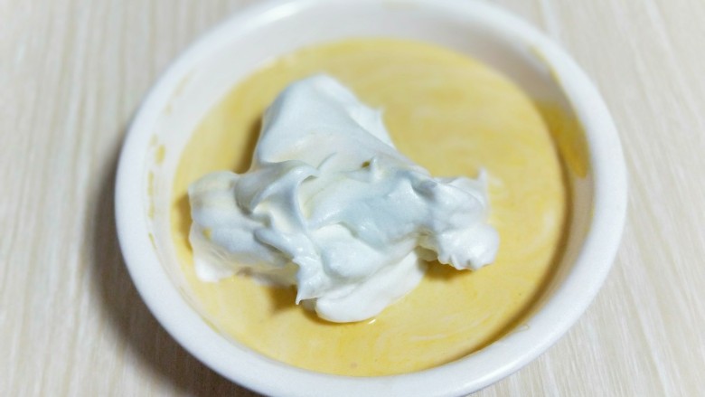 香甜口感丰富的南瓜戚风蛋糕,再取三分之一的蛋白霜加入蛋黄糊中，继续上面的手法，翻拌直至看不到蛋白霜。