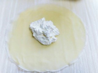 春节餐桌上不可缺少的芒果班戟,取一张皮，放入打发的奶油。