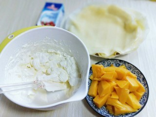 春节餐桌上不可缺少的芒果班戟,芒果去皮，切块。奶油打至全发。
