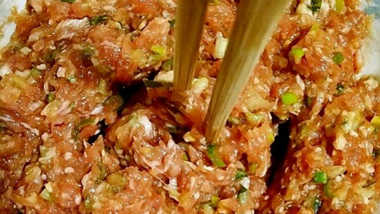 文艺吃货的花式蒸饺,把肉馅搅上劲儿，用筷子搅的，筷子能在肉馅中立住不倒就是搅上劲儿，搅好了。