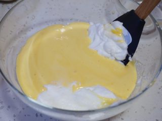 舒芙蕾松饼,把拌好的面糊反倒回蛋清的盆中，用刮刀翻拌均匀。