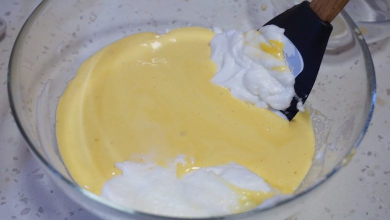 舒芙蕾松饼,把拌好的面糊反倒回蛋清的盆中，用刮刀翻拌均匀。