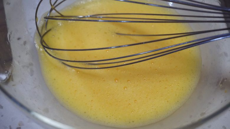 舒芙蕾松饼,用手动打蛋器把蛋黄打散，同水和油打匀。