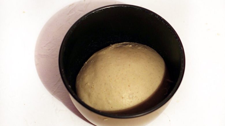 杏仁碎糯米排包,将面团滚圆入盆，上覆保鲜膜。