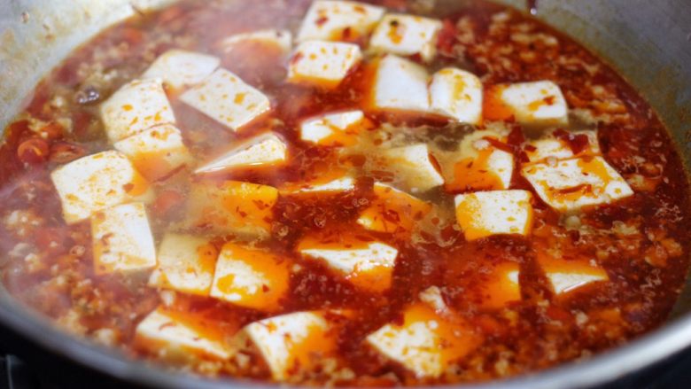 麻婆豆腐,放入豆腐，不要用铲子铲，轻轻晃动锅子，让豆腐均匀裹上汤汁。煮2,3分钟，让豆腐更入味