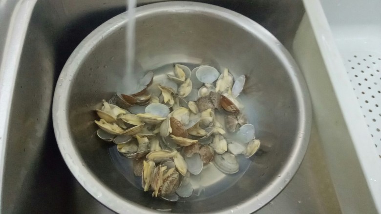 酱炒花蛤,放入水管下，一边流水一边取出里面的内脏。