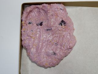 花生紫薯牛轧糖,取出放入不粘盘中。带上手套。