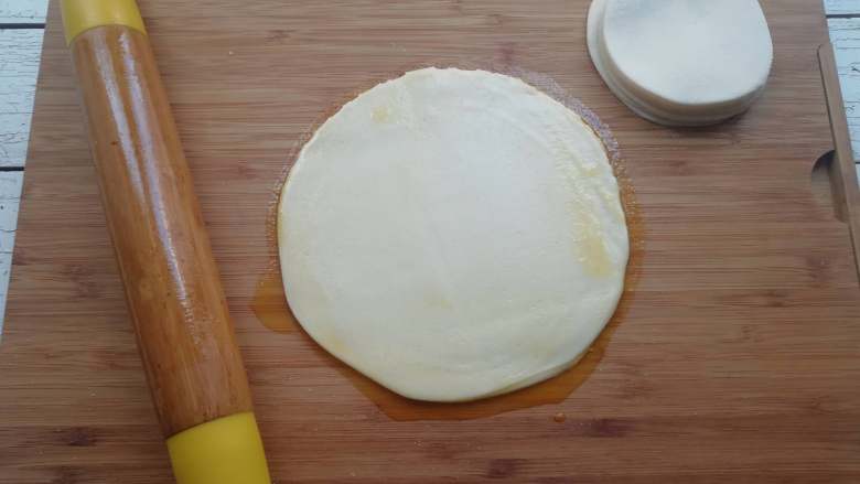 饺子皮版春饼,用擀面杖从饺子皮中间往四周擀，将饺子皮擀成一张大饼