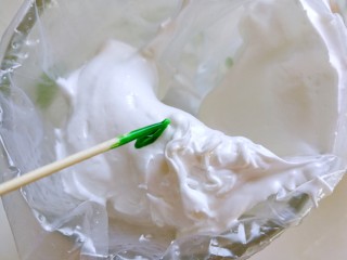 甜甜蜜蜜过新年～柠檬蛋白糖,挖四分之一勺蛋白放到裱花袋里面，用牙签挑一点色素放在蛋白上