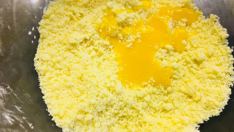 芝士蓝莓派,将蛋黄液倒入搓好的黄油颗粒中