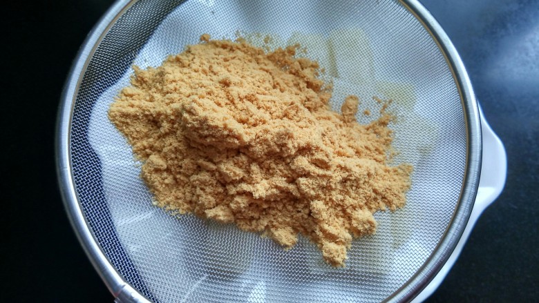 做年货  黄豆面红糖糍粑,将黄豆粉筛入盘中。