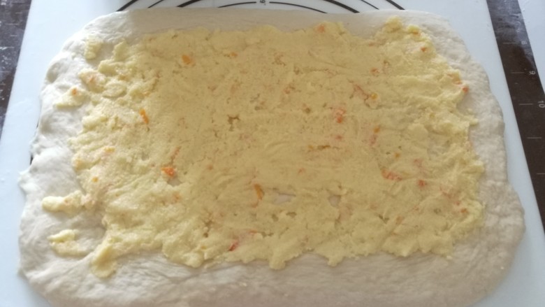 橙皮奶酥枫糖土司,​9、  醒好的面团擀成长方形，最长的一边不要超过模具长度，抹上奶酥馅