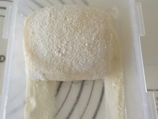 超级柔软的炼奶土司,卷好的面团在奶粉中滚一圈