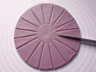 紫薯花馒头,用刀将面饼均匀地切成16份，中央保留不要切断。