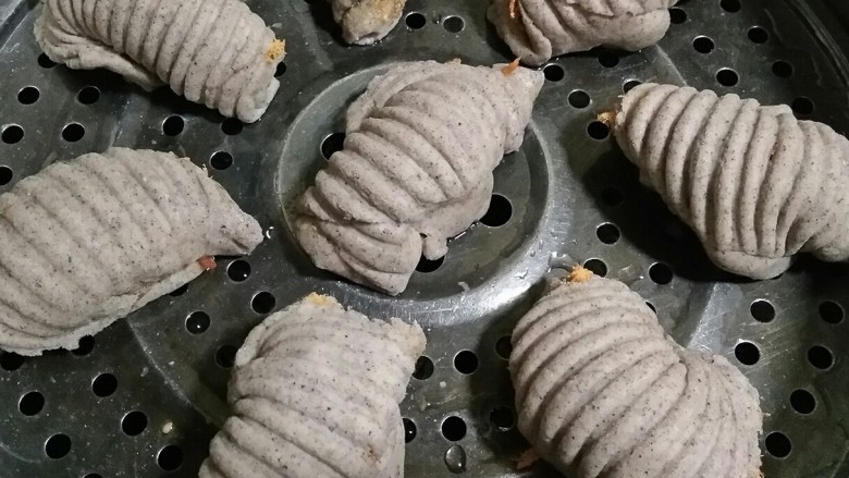 黑米海螺肉松卷,在篦子上抹一层薄薄的橄榄油防粘，将做好的海螺卷放在篦子上，盖上锅盖二次醒发15-20分钟，然后开中大火隔水蒸20分钟，之后关火焖5分钟。