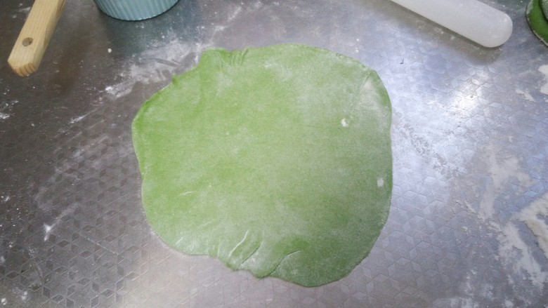 绿油油的菠菜春饼,取一个叠好的剂子擀成圆薄饼
