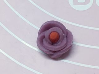 情侣鹅,另取一小点红色面搓一根小圆柱做花芯，再把切开的紫色花瓣一片片都粘贴在红色花芯上，稍微整理下，做成一朵小花，如上图。